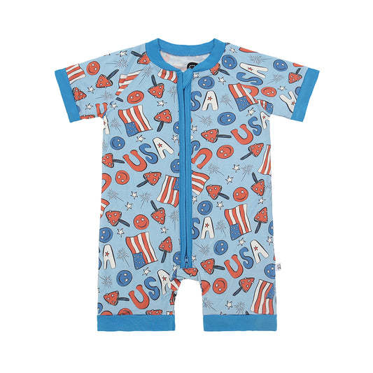 The Stars & Shrooms • Bamboo Shorty (Classic Fit) is a short-sleeve baby romper made from ultra-soft bamboo viscose, featuring blue trim and USA-themed graphics—flags, stars, and “USA”—in red, white, and blue on light blue.