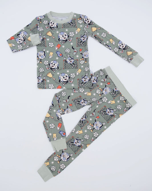 The Kickoff • 2 Piece Bamboo Set (Classic Fit) is a children’s long-sleeve pajama set in light green bamboo viscose with soccer balls, gloves, goals, whistles, yellow and red cards from our cozy collection.
