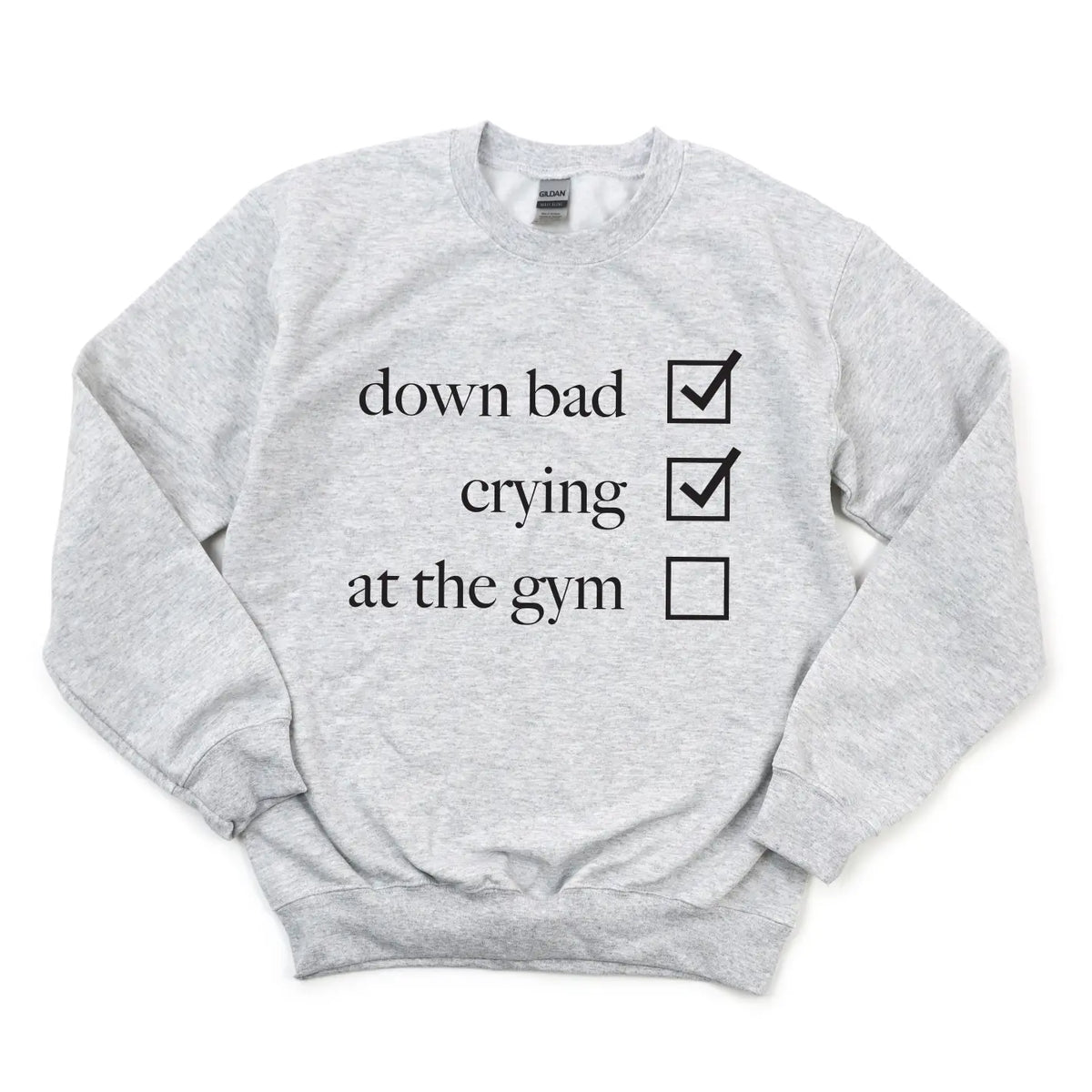 The Not at the Gym • Ash Pullover is a light gray cotton/polyester unisex sweatshirt with down bad and crying marked and at the gym unmarked in black text on the front.