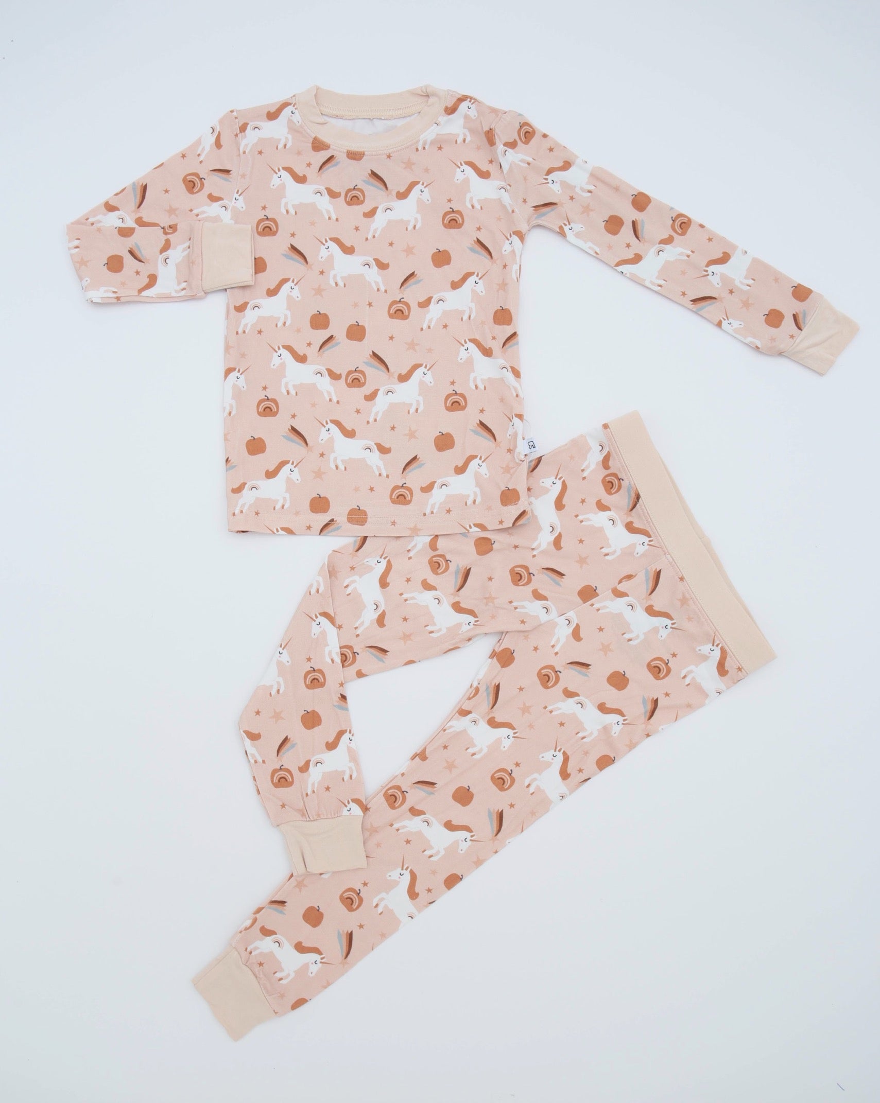 The Fall Unicorns • 2 Piece Bamboo Set (Classic Fit) features a light pink background with white unicorns and orange pumpkins. Made from soft bamboo fabric, this cozy set includes a long-sleeved top and matching pants—great for sensitive skin.