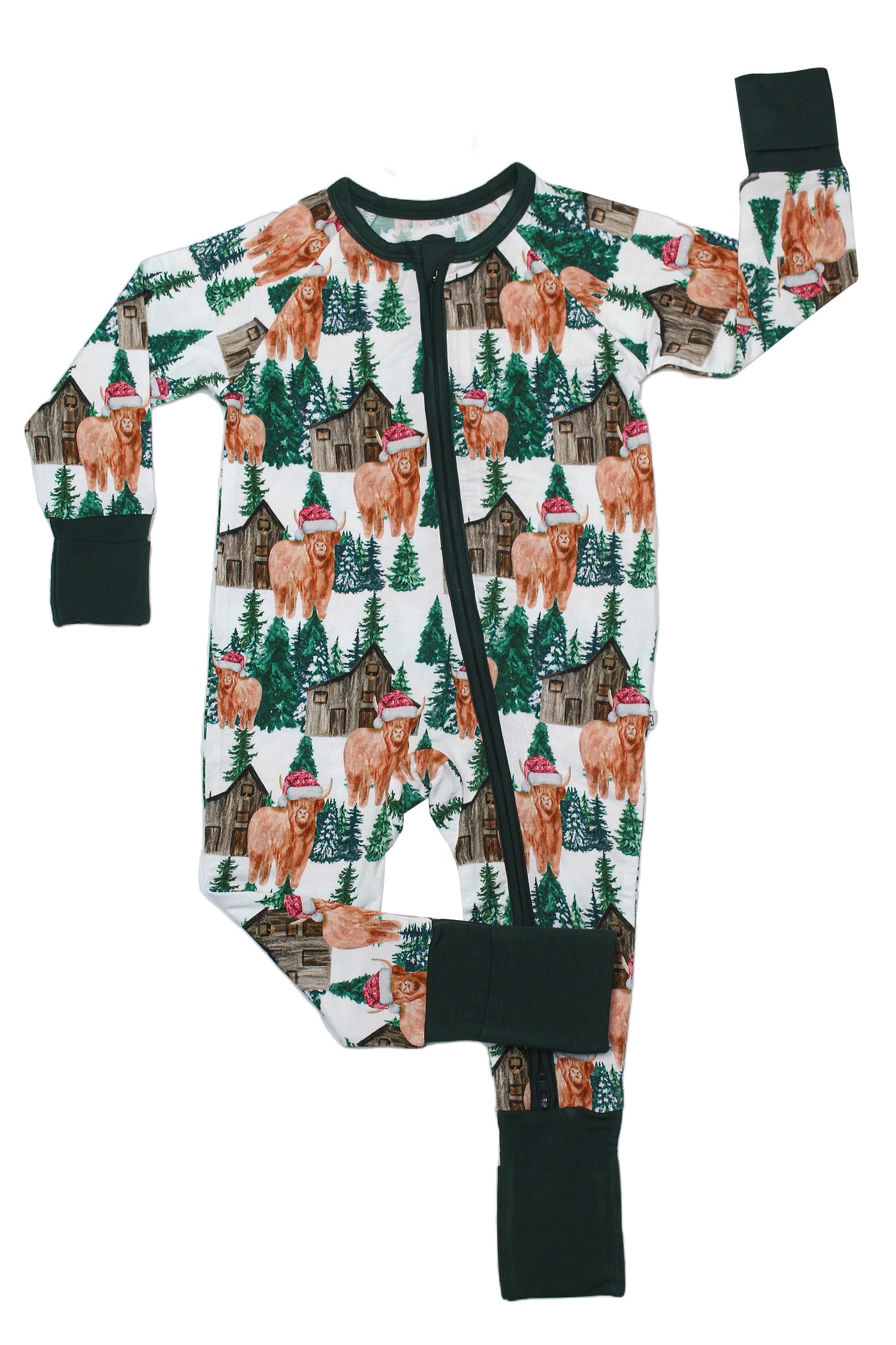 The Santa Cows • Bamboo Zippy (Updated Fit) is a long-sleeve baby romper with a woodland print of brown cows in hats, pine trees, and cabins. Made from soft bamboo for sensitive skin, it features black cuffs and a front black zipper.