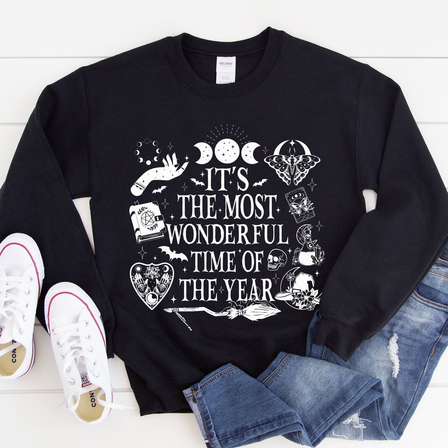 The Most Wonderful Time • Black Pullover features white mystical illustrations and festive text on soft unisex fabric. Styled with blue jeans and white Converse, it offers a comfy fit perfect for the season.