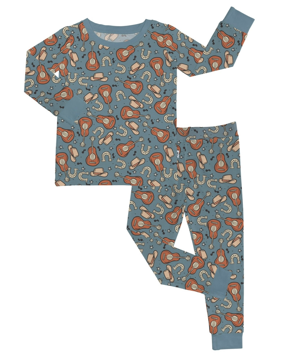 The Howdy • 2 Piece Bamboo Set (Updated Fit) features blue children’s pajamas with a fun pattern of brown guitars, cowboy hats, and horseshoes. Made from bamboo viscose, this set includes a long-sleeve top and matching pants with blue cuffs.
