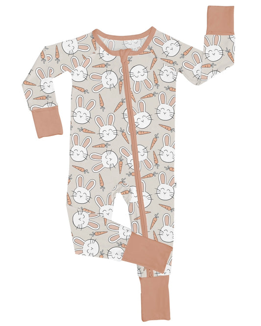 The Snuggle Bunny • Bamboo Zippy (Updated Fit) is a beige bamboo onesie with light brown cuffs and zipper, featuring white bunny faces and orange carrots. Made from soft bamboo viscose for ultimate comfort.