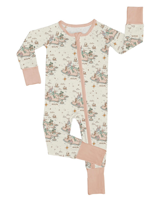 The Never Neverland • Bamboo Zippy (Updated Fit) is a cozy children’s footed onesie with an illustrated fairytale map on cream, featuring castles and ships, light pink cuffs and trim, a diagonal zipper, and soft bamboo fabric.