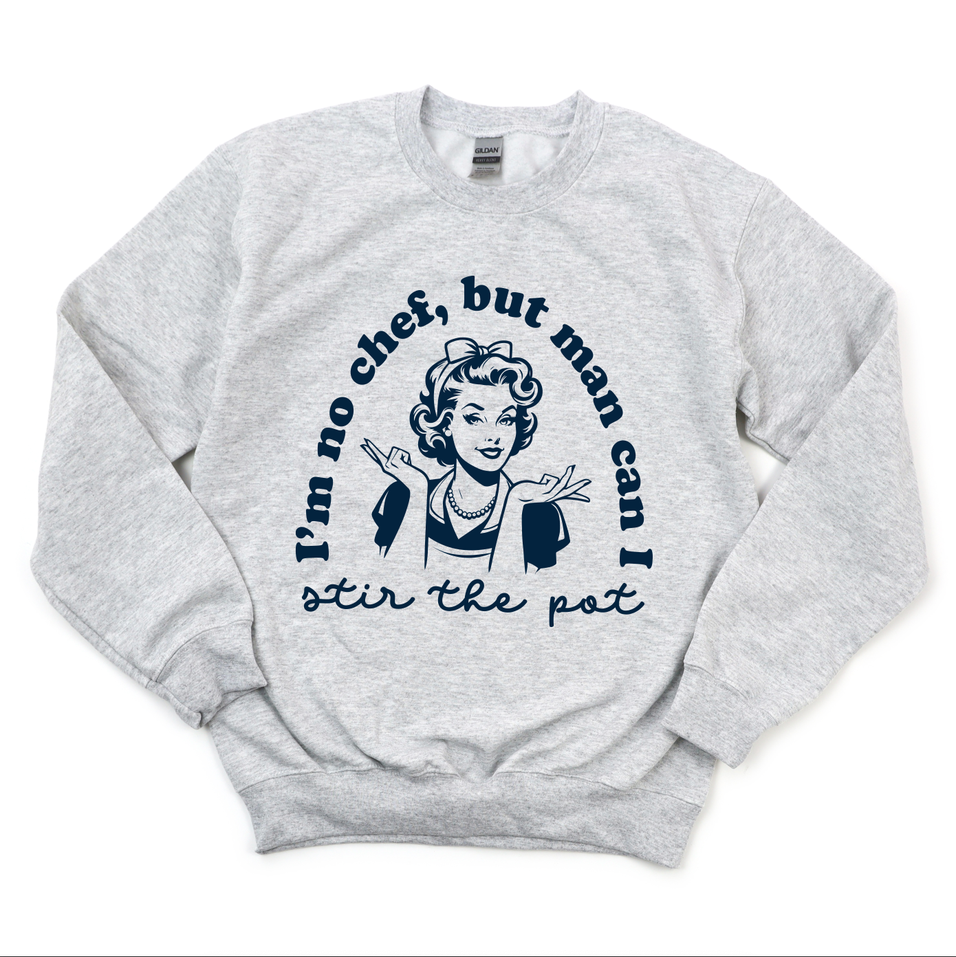 The Stir the Pot • Ash Pullover is a comfy grey sweatshirt with a retro-style woman shrugging and Im no chef, but man can I stir the pot in navy text — perfect for timeless style.