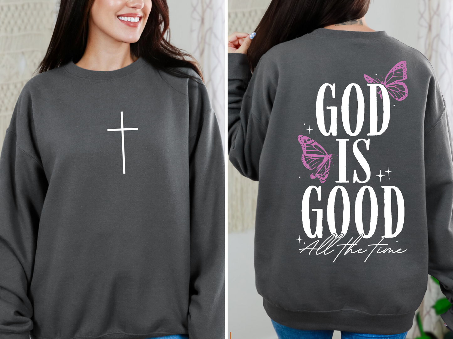 A woman wears the God is Good • Asphalt Tee or Pullover, featuring a white cross on the front and “God is good all the time” with pink butterflies and stars on the back. This cozy Bella/Canvas piece comes in unisex sizing.