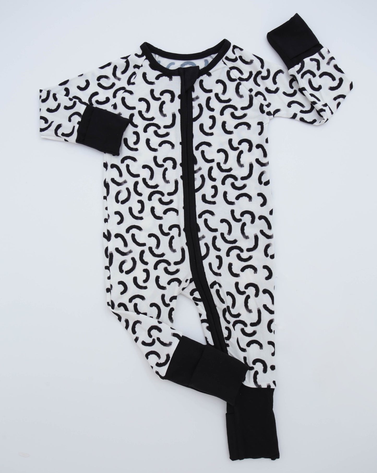 The Monochrome • Bamboo Zippy (Classic Fit) is a cozy black and white baby onesie with abstract curved shapes, solid black cuffs, collar, and zipper on a white background—crafted from soft bamboo viscose for all-day comfort.