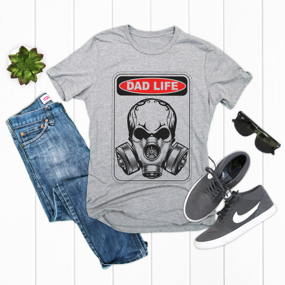 The Danger! • Dad Life Tee—gray, combed and ring-spun cotton with a DAD LIFE gas mask graphic—styled with folded jeans, gray Nike sneakers, black sunglasses, and a small succulent on a white wooden backdrop.