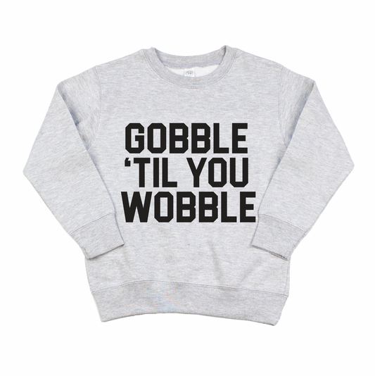 The GOBBLE • Pullover is a light gray sweatshirt with bold black GOBBLE TIL YOU WOBBLE text on the front and an oversized fit for ultimate comfort.