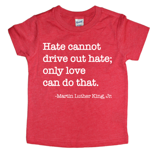 The MLK Love Tee is a red Kavio t-shirt featuring Hate cannot drive out hate; only love can do that. - Martin Luther King, Jr. in white on the front. Each shirt is made-to-order.
