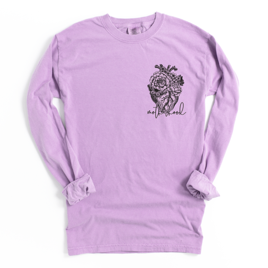 The Heart Motherhood • Long Sleeve is a unisex lavender shirt with a black floral heart and motherhood script on the left chest, made from soft ring-spun cotton and finished with rolled cuffs for comfort.