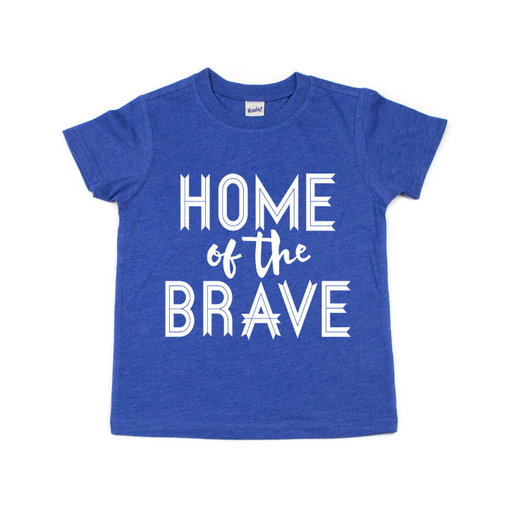 The Home of the Brave • Kids Tee is a blue, made-to-order short-sleeve shirt featuring HOME of the BRAVE in bold white letters on the front, made from super-soft fabric for all-day comfort.