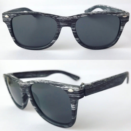 Two views of Marbled Sunnies • Kids show a white wood-grain look on black frames with silver rivets. Dark lenses and a classic design make these sunglasses a must-have kids accessory. Background is plain white.