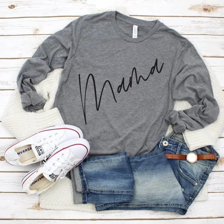 A gray Mama Diagonal • Long Sleeved tee styled with blue denim shorts, brown belt, white sneakers, cozy white knit cardigan, and white watch—shown on a white wood surface. Unisex sizing ensures a relaxed fit.