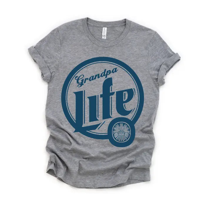 The Grandpa Life • Beer Tee is a gray crew neck t-shirt with rolled sleeves, made from soft ring-spun cotton. It features a large navy blue circle design, Grandpa Life in script, and a small wheel graphic at the lower right.