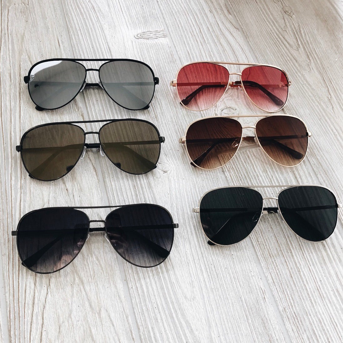 Six pairs of Bri Sunglasses • Adult, each with different colored lenses and frames, feature UV400 protection and are displayed in two neat rows on a light wooden surface.
