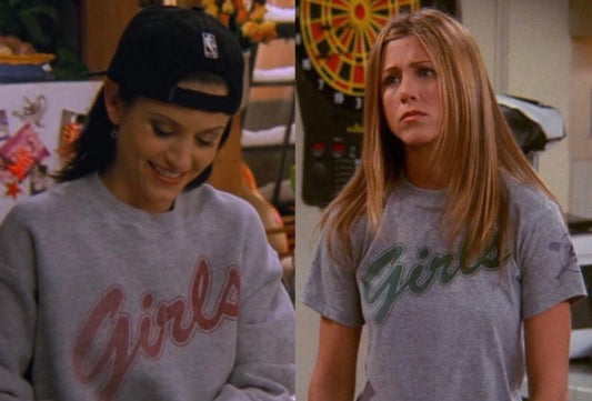 Split image: On the left, a woman with dark hair wears a backward black cap and the Girls • Pullover, smiling and looking down. On the right, another woman with straight hair wears the same comfy unisex fit Girls • Pullover, looking serious.