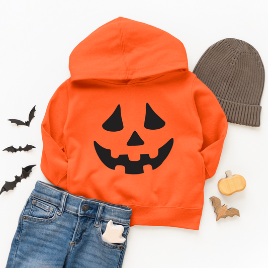 A Jack O Lantern • Orange Hoodie, blue jeans with a ghost detail, gray knit hat, and small Halloween decorations (bats, pumpkin), all arranged on a white background.