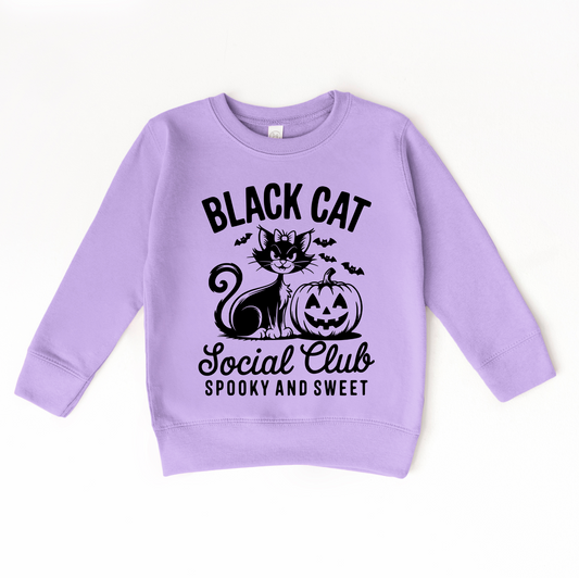The Black Cat Social Club • Kids Pullover is a lavender black sweatshirt featuring a smiling cat with a bow, pumpkin, bats, and BLACK CAT Social Club SPOOKY AND SWEET text. Available in kids unisex sizing for the perfect fit.