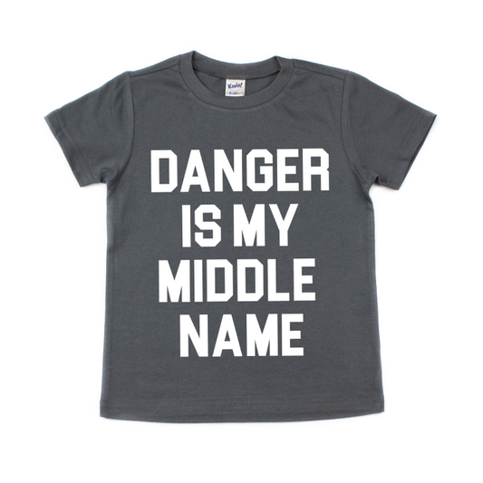 The DANGER • Kids Tee is a charcoal shirt with bold white DANGER IS MY MIDDLE NAME print. Check Kavio Size Specs for the perfect fit.