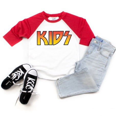 The KIDS • Raglan features bold yellow KIDS lettering on white and red, paired with light blue jeans and black-and-white sneakers—perfect for your little rocker with a true to size fit.